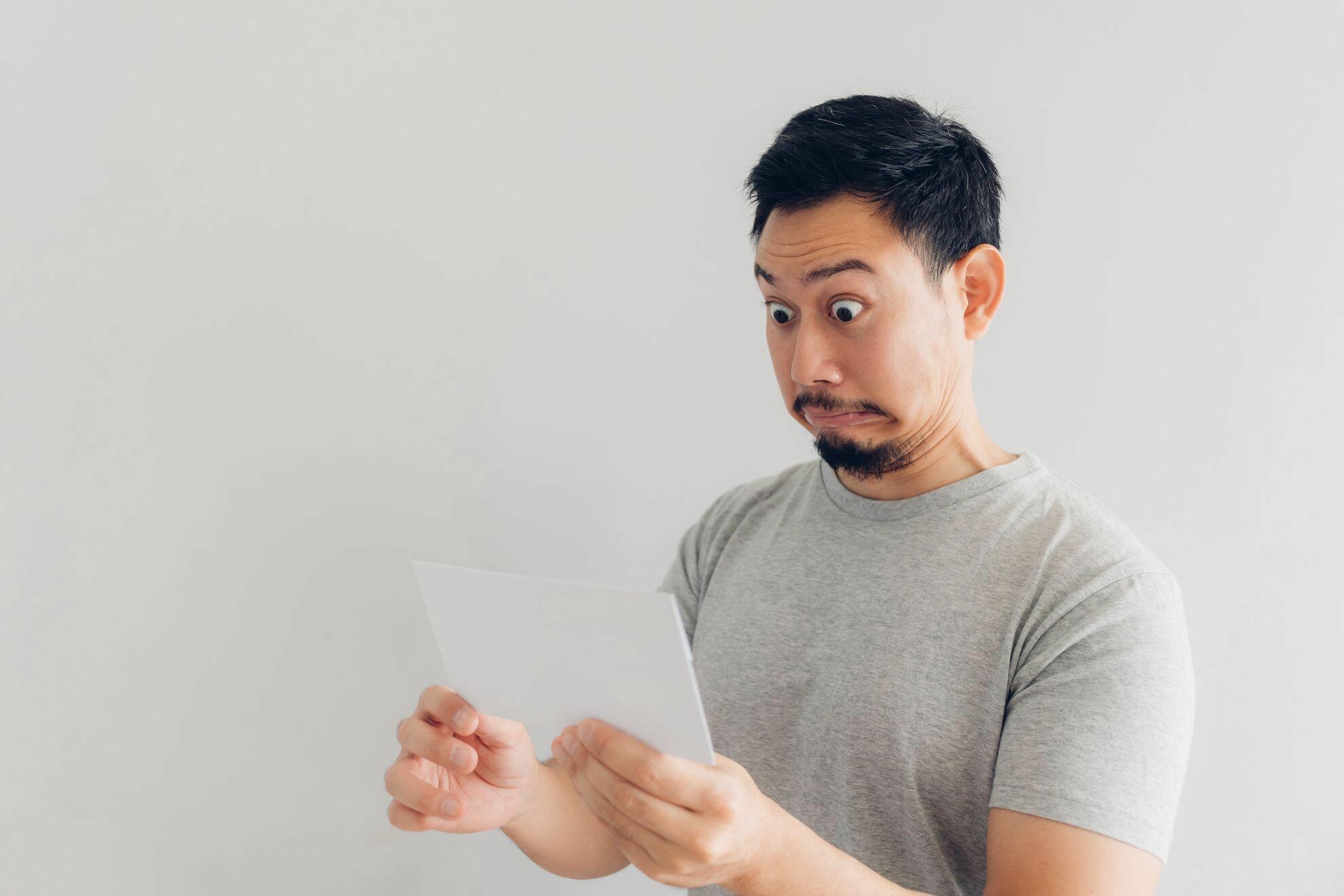 Homem vendo extrato do banco com desconto de dívida